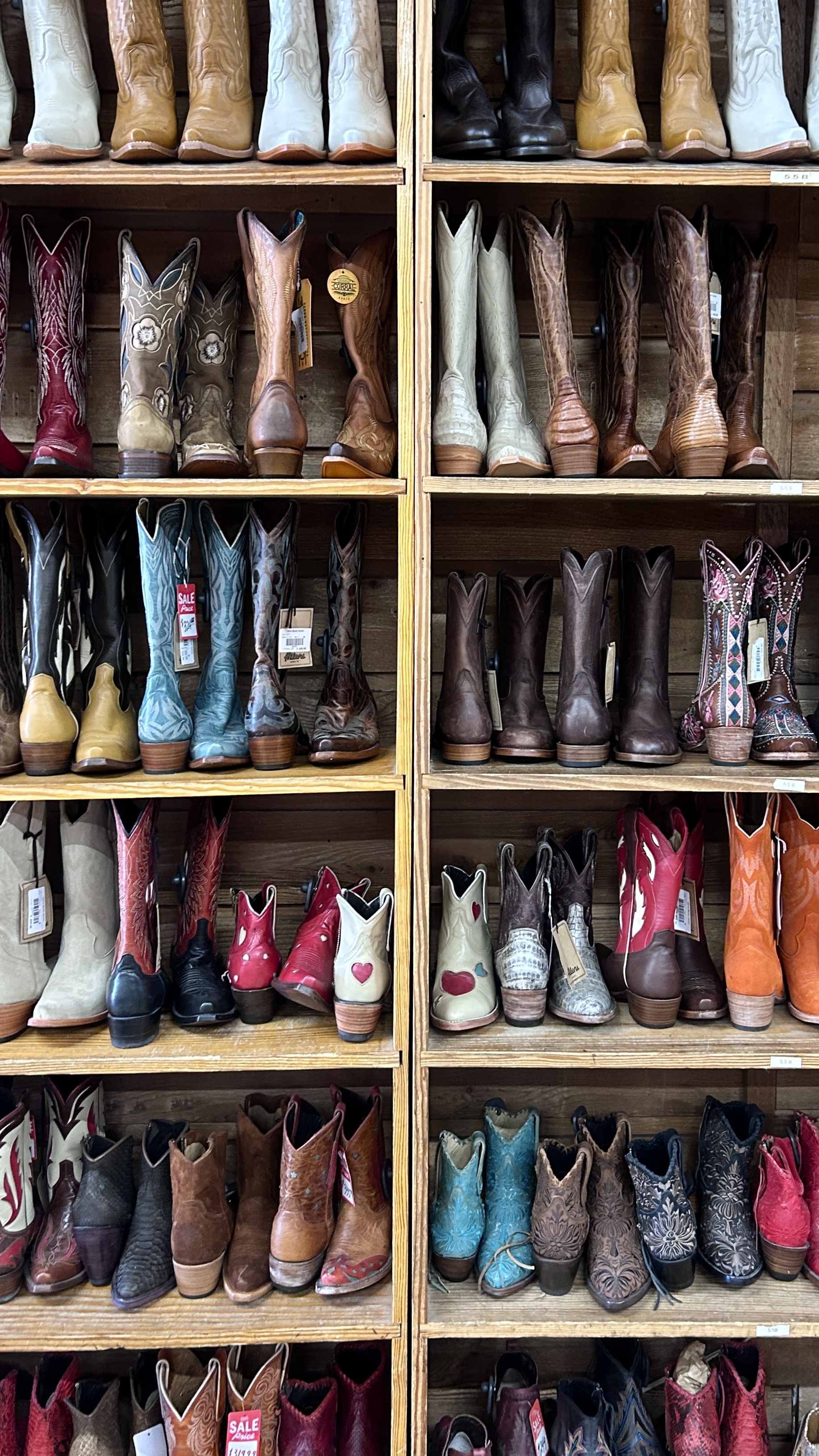 A wall of cowboy boots on wooden shelves in a Texas shop